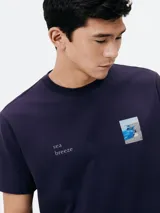 Camiseta azul marino de algodón con estampa rectangular de paisaje en el frente.