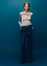Jeans wide leg de tiro medio, confeccionados en denim azul oscuro con apliques de cristales distribuidos en toda la prenda. Cuenta con diseño de cinco bolsillos, trabillas para cinto y cierre frontal con botón y cremallera.