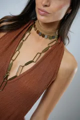 Mono largo color marrón con textura, escote halter, corte holgado, cinturón de cuero con estampado animal y cierre frontal con botones.