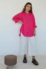 Camisa fucsia de corte oversize con cuello clásico y mangas largas.