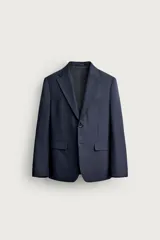 Blazer regular fit azul marino confeccionada en tejido con 20% de lana. Cuenta con cuello con solapas de muesca, manga larga con botones en los puños, bolsillos de vivo en el pecho y de solapa en la cadera, y cierre frontal con botones.