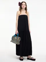 Vestido largo strapless negro de fit amplio con volados en el bajo.