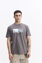 Remera de manga corta color gris oscuro con cuello redondo y un estampado rectangular frontal que simula una obra de arte paisajística en blanco y negro.