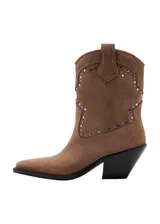 Botines de estilo texano en color marrón claro, confeccionados en piel bovina, con diseño de caña baja, puntera fina y detalles de tachas metálicas en la parte frontal y lateral.