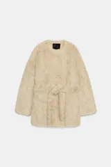 Abrigo de Zara Woman Collection con textura efecto pelo, cuello redondo y manga larga. Presenta un diseño cruzado con cinturón ajustable del mismo tejido y bolsillos delanteros.