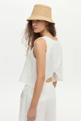 Top blanco de lino sin mangas, con diseño cruzado en la espalda y corte holgado.
