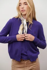 Cardigan azul de punto fino, con cuello redondo y cierre frontal de botones negros.