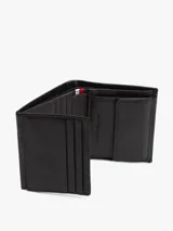 Billetera plegable en tres partes de cuero negro con textura acanalada. Presenta un logo esmaltado de la marca en la esquina inferior derecha. Incluye compartimentos para billetes, ranuras para tarjetas y un bolsillo para monedas.
