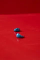 Aros tipo argolla semicircular de acetato color azul con lunares rojos estampados.