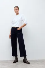 Remera blanca de manga tres cuartos con detalles de bordado calado en el frente y en los hombros, con cuello redondo y puños elásticos.