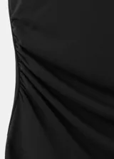 Vestido midi negro con diseño asimétrico, cuello redondo drapeado y detalle de frunces en el lateral. Falda de corte evasé con terminación en puntas.