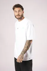 Remera blanca de algodón con cuello redondo, corte holgado y estampado pequeño en el frente.