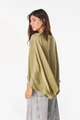 Blusa de algodón azul marino con escote en V, mangas murciélago amplias y diseño corto de corte asimétrico.