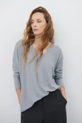 Sweater de punto con escote en V, manga larga y corte holgado. Presenta un diseño minimalista y versátil, ideal para uso diario.