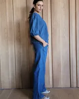 Pantalón de denim azul, de corte recto y tiro alto, con cintura elástica y cordón ajustable. Tiene bolsillos laterales.