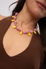Collar corto de cuentas con dijes en forma de gota color amarillo, combinado con piedras rosadas y lilas.