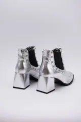 Botas cortas negras de cuero con elásticos laterales, taco cuadrado y apliques de tachas plateadas.