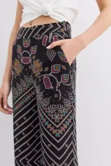 Pantalon tipo palazzo de tiro alto, confeccionado en viscosa estampada con diseño geométrico multicolor. Presenta cierre lateral invisible y bolsillos diagonales.