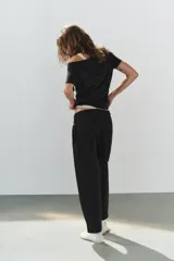 Pantalón de algodón negro con tiro medio, cintura elástica, pierna recta y grandes bolsillos laterales aplicados.