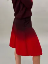 Falda midi de crepe de lana, teñida a mano con degradado de bordó a rojo, con bolsillos laterales y tablas.
