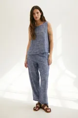 Top sin mangas de corte recto y holgado, confeccionado en tejido de lino con textura jaspeada en tono azul. Presenta cuello redondo y un diseño minimalista ideal para climas cálidos.