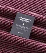 Suéter de punto pesado con textura acanalada, cuello redondo y mangas largas con diseño raglán. Presenta acabados acanalados en cuello, puños y ruedo.