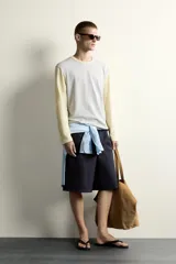 Camiseta de corte relajado con diseño color block, cuerpo en gris melange y mangas largas y cuello redondo en amarillo pastel.