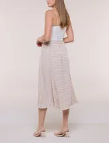 Falda midi evasé de color beige con diseño a rayas horizontales y verticales blancas, cintura alta elastizada y caída fluida.