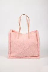 Cartera tipo tote bag confeccionada en tejido efecto corderito color rosado, con asas de hombro en cuero sintético a tono.