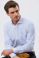 Camisa de vestir de manga larga con diseño a rayas finas en color celeste y blanco, cuello camisero tradicional, cierre frontal con botones y bordado pequeño en el pecho.