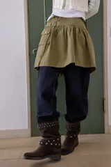 Falda corta de tiro medio color verde militar, con diseño de volumen, bolsillo tipo cargo en el delantero, detalle de trabilla con hebilla metálica en la cintura y cierre lateral oculto.