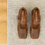 Zapato estilo Mary Jane de cuero vacuno con acabado brillante, punta cuadrada y taco bloque. Cuenta con una tira ajustable sobre el empeine con hebilla metálica.