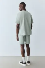 Short deportivo color verde claro, de corte regular, con cintura elástica ajustable con cordón, bolsillos laterales y un bolsillo trasero.