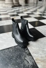 Botas negras de cuero con punta cuadrada y cierre lateral con cremallera.