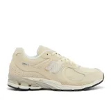 Championes urbanos New Balance modelo 2002R, color beige, confeccionados en una combinación de gamuza y malla transpirable. Presentan el logo N característico en los laterales, entresuela con tecnología N-ergy para mayor amortiguación y suela de goma resistente.