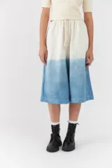 Bermuda estilo jort con diseño degradado en tonos blanco y azul, de corte ancho y largo midi con cintura elástica y cordón ajustable.