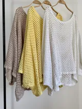 Sweater de tejido en red color amarillo mantequilla, con diseño oversize y amplio, mangas largas y caída holgada ideal para superposiciones.