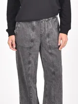 Pantalon de jean con efecto lavado, corte recto y holgado, con costuras verticales decorativas en el frente y bolsillos laterales.