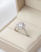 Anillo de plata 925 con diseño floral central compuesto por circonias brillantes y banda con pavé de piedras pequeñas.