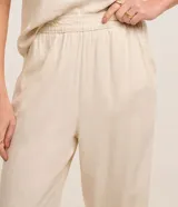 Pantalón recto de sarga color beige, de corte clásico y cintura elástica.
