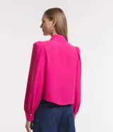 Camisa celeste de crepé con cuello inglés, manga larga abullonada y abotonadura frontal.