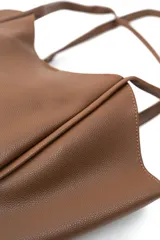 Bolso tipo tote bag color tostado, con doble asa de hombro y diseño estructurado, acompañado de un pequeño neceser con cierre.