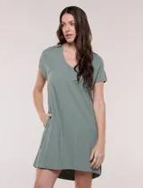 Vestido corto de lino color celeste con cuello camisero, escote en V, mangas cortas, bolsillos laterales invisibles y silueta holgada.