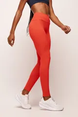 Calza deportiva larga de tiro alto en color rojo, confeccionada en poliamida de alta performance con cintura ancha de sustentación firme y diseño sin costura frontal.