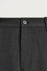 Pantalón cargo straight fit de color gris oscuro, confeccionado en tejido elástico. Cuenta con bolsillos frontales, bolsillos traseros de vivo y bolsillos plastrón con solapa en las perneras. Cierre frontal con cremallera y botón.