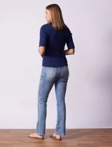 Buzo azul de tejido acanalado, con cuello solapa y escote en V en tejido calado.