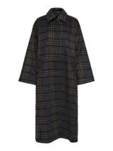 Abrigo largo de corte recto con estampado de cuadros en tonos oscuros, cuello camisero y cierre frontal con botones. Presenta un diseño estructurado con bolsillos laterales y forro interior acolchado.