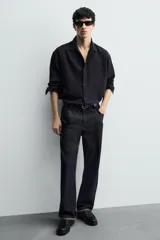 Zapato tipo Mary Jane color negro, con cierre mediante hebilla lateral, parte superior fabricada en piel, detalle de bordón en el empeine, horma redonda y suela con volumen.