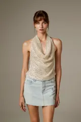 Falda mini de jean con diseño recto, bolsillos tradicionales y aplicación de strass brillante en el lateral.