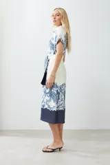 Vestido midi color blanco con estampado de paisley en azul y cinturón de lazo.